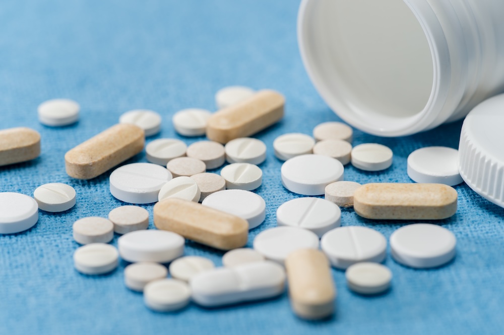 Painkillers spilling from bottle onto table.